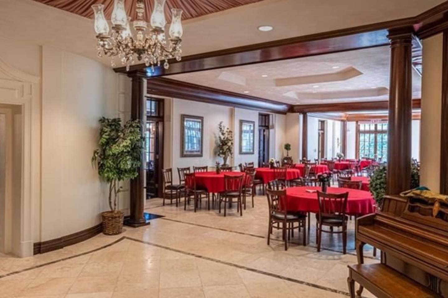 Elegant dining hall with round tables and chandelier lighting